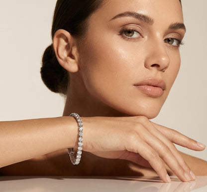 Woman wearing a diamond bracelet on a neutral background