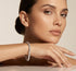 Woman wearing a diamond bracelet on a neutral background